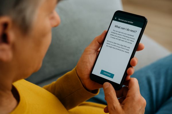 Pessoa adulta tentando recuperar conta do WhatsApp após clonagem